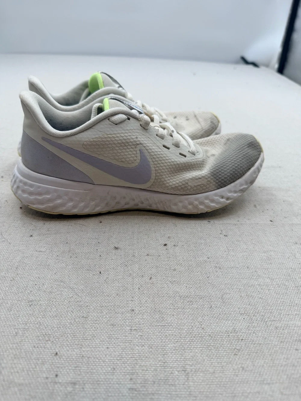 Nike Women’s Revolution Sneakers in Cream with Light Purple Swoosh